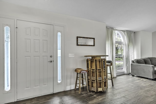 entrance foyer with dark wood finished floors and baseboards