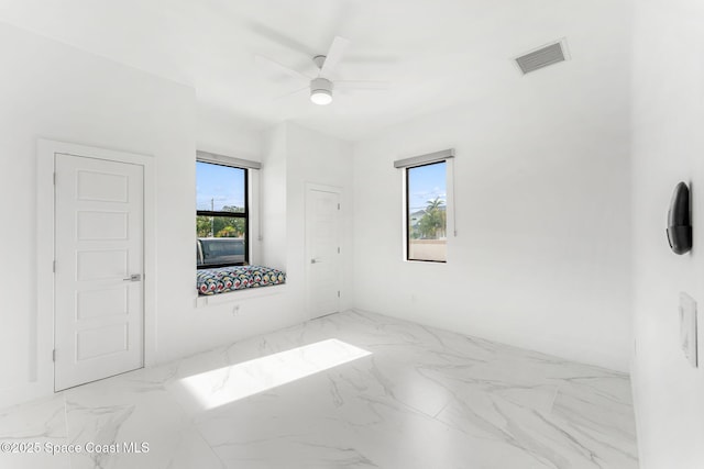 2355 N Riverside Dr, Indialantic, FL 32903 - spare room featuring a healthy amount of sunlight, a ceiling fan, marble finish floor, and visible vents