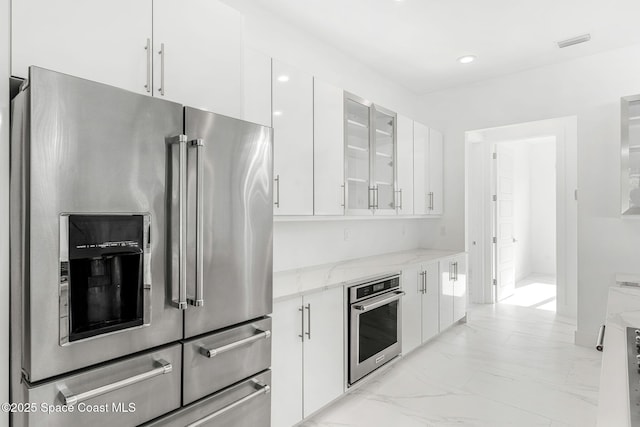 2355 N Riverside Dr, Indialantic, FL 32903 - kitchen featuring light stone countertops, white cabinets, marble finish floor, glass insert cabinets, and stainless steel appliances