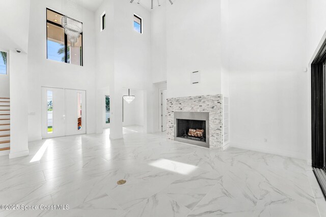 2355 N Riverside Dr, Indialantic, FL 32903 - unfurnished living room with marble finish floor, a high ceiling, stairway, and a tile fireplace