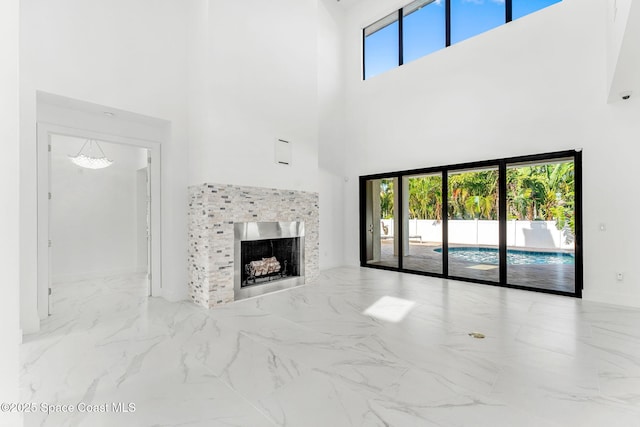 2355 N Riverside Dr, Indialantic, FL 32903 - unfurnished living room featuring a high ceiling, a fireplace, and marble finish floor
