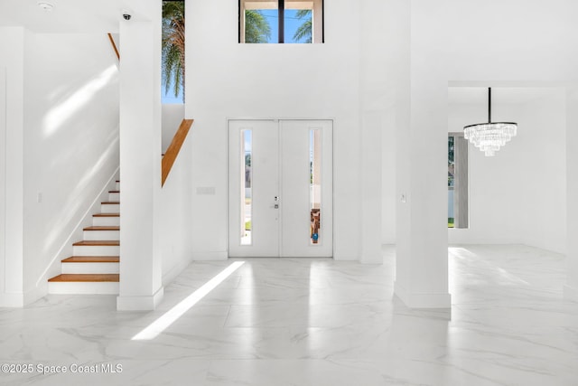 2355 N Riverside Dr, Indialantic, FL 32903 - entryway with baseboards, marble finish floor, a high ceiling, and a chandelier