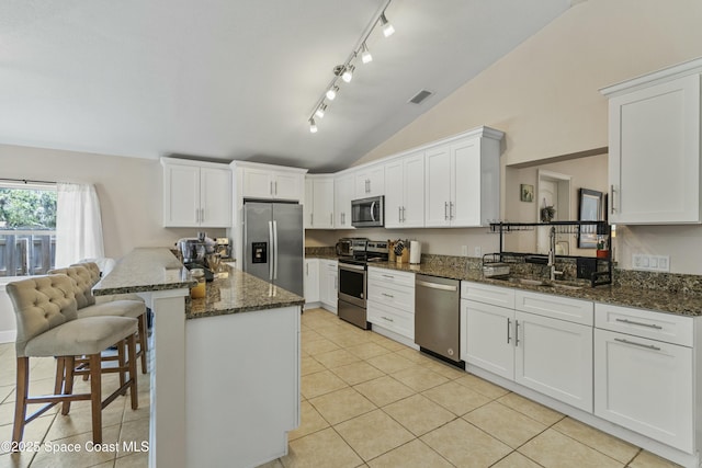 1044 Bernice Rd, Rockledge, FL 32955 - kitchen with visible vents, a kitchen bar, a sink, appliances with stainless steel finishes, and vaulted ceiling