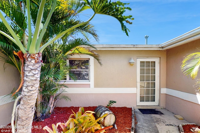 property entrance featuring stucco siding