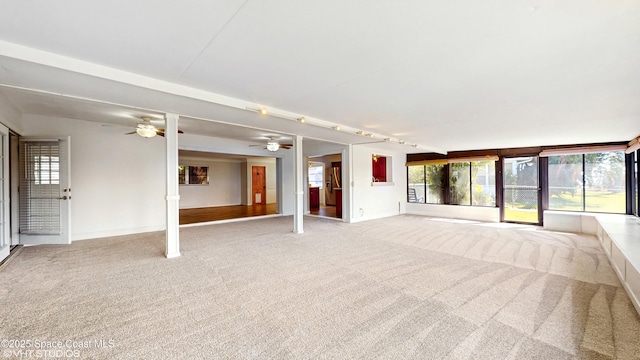 unfurnished living room featuring ceiling fan, baseboards, and light carpet