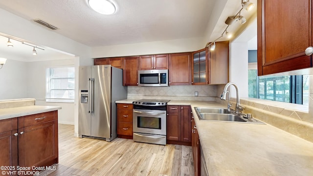 kitchen featuring a sink, visible vents, stainless steel appliances, light wood-style floors, and track lighting