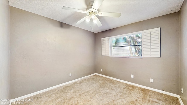 spare room featuring baseboards, a ceiling fan, a textured ceiling, and carpet