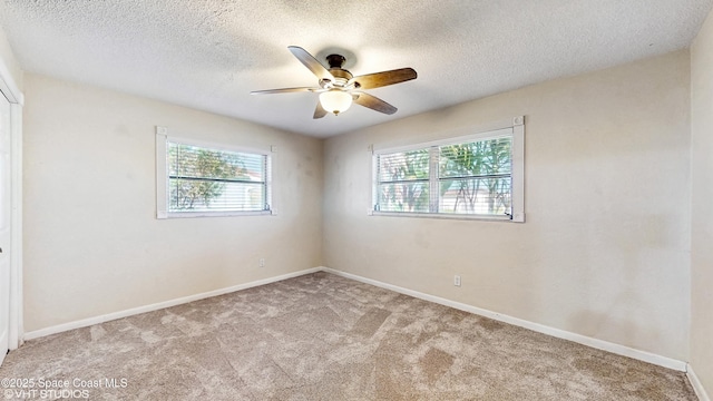 spare room with baseboards, a ceiling fan, a textured ceiling, and carpet flooring