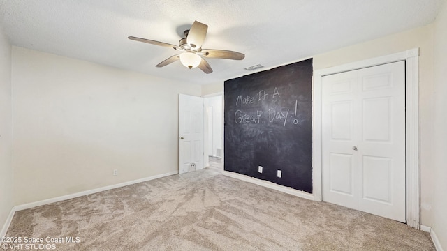 unfurnished bedroom featuring visible vents, ceiling fan, baseboards, and carpet floors