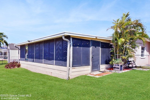 back of property with a lawn, fence, and a sunroom
