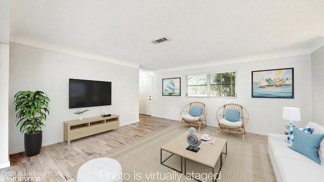 living area featuring wood finished floors and visible vents