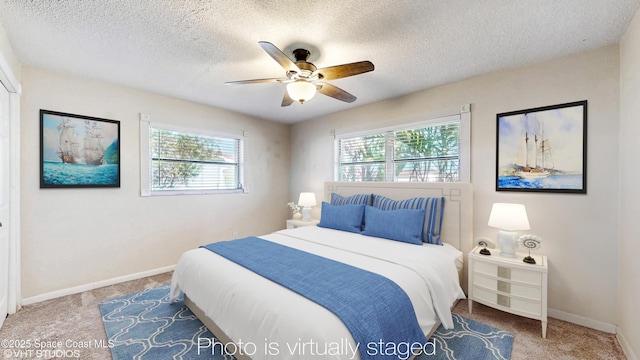 bedroom with a textured ceiling, carpet flooring, and a ceiling fan