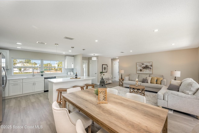 dining area featuring visible vents, light wood-type flooring, and recessed lighting