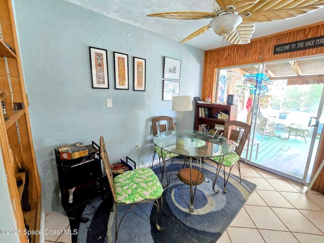 305 Harrison Ave, Cape Canaveral, FL 32920 - dining area with a textured wall, light tile patterned flooring, ceiling fan, and wooden walls
