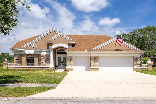 4800 Solitary Dr, Rockledge, FL 32955 - craftsman inspired home with a front yard, a garage, driveway, stone siding, and french doors