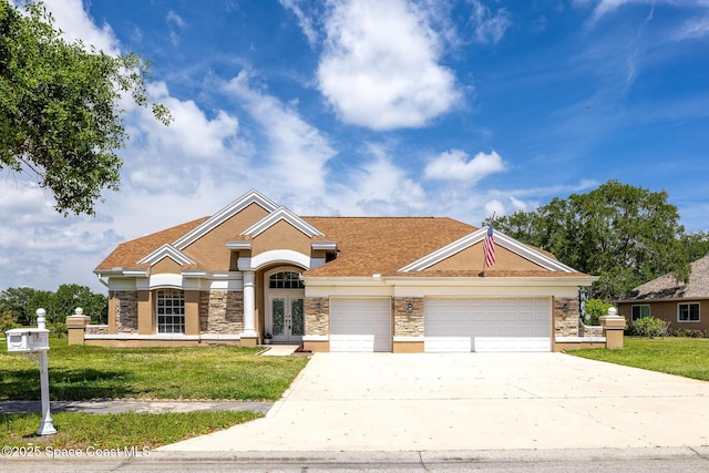 4800 Solitary Dr, Rockledge, FL 32955 - view of front of home featuring driveway, french doors, an attached garage, and stone siding