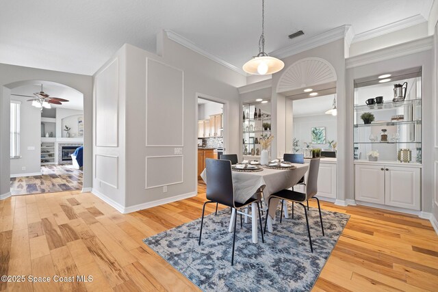 4800 Solitary Dr, Rockledge, FL 32955 - dining space featuring crown molding, light wood-style floors, ceiling fan, visible vents, and arched walkways