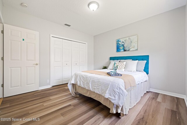 4800 Solitary Dr, Rockledge, FL 32955 - bedroom with wood finished floors, visible vents, a closet, and baseboards