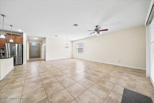 3624 Sansome Cir, Melbourne, FL 32940 - unfurnished living room with a ceiling fan, light tile patterned floors, a chandelier, baseboards, and a textured ceiling
