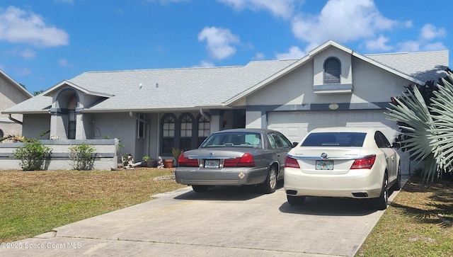 single story home with a front lawn, a garage, roof with shingles, concrete driveway, and stucco siding