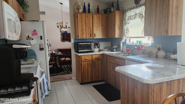 kitchen featuring light countertops, brown cabinetry, and white appliances