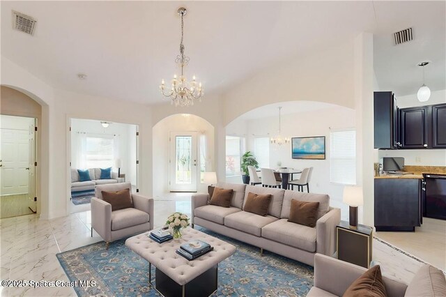 115 Briarcliff Cir, Sebastian, FL 32958 - living room with an inviting chandelier, arched walkways, marble finish floor, and visible vents