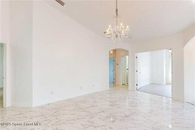 115 Briarcliff Cir, Sebastian, FL 32958 - empty room with visible vents, arched walkways, marble finish floor, and a notable chandelier