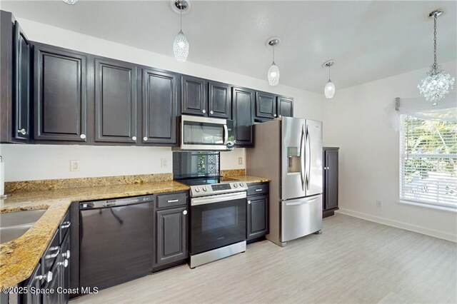 115 Briarcliff Cir, Sebastian, FL 32958 - kitchen with stainless steel appliances, baseboards, hanging light fixtures, and light wood finished floors