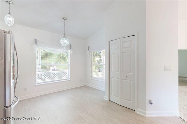 115 Briarcliff Cir, Sebastian, FL 32958 - unfurnished dining area with baseboards, light wood-style flooring, lofted ceiling, and a notable chandelier