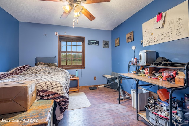 bedroom featuring a textured ceiling, ceiling fan, hardwood / wood-style flooring, and baseboards