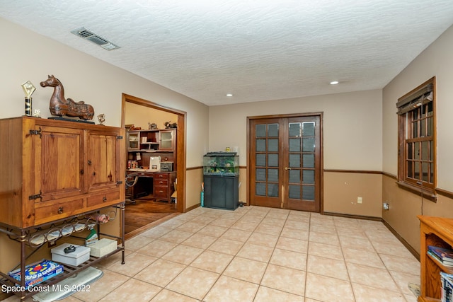 interior space with recessed lighting, light tile patterned floors, visible vents, a textured ceiling, and french doors