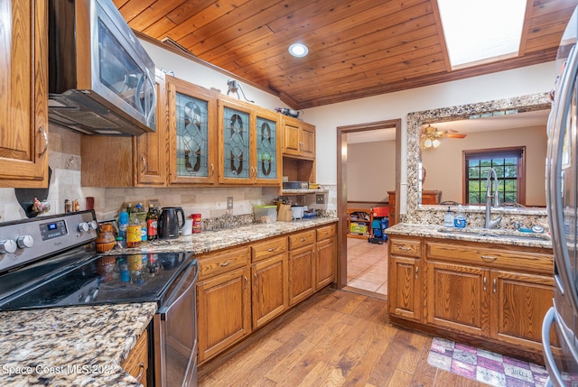 kitchen with tasteful backsplash, brown cabinets, stainless steel appliances, and wooden ceiling