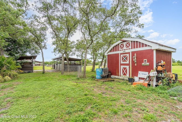 view of barn featuring a carport and a lawn