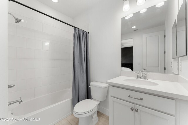 8048 Gullen Dr, Melbourne, FL 32940 - bathroom featuring vanity, wood finished floors, shower / bath combination with curtain, toilet, and baseboards