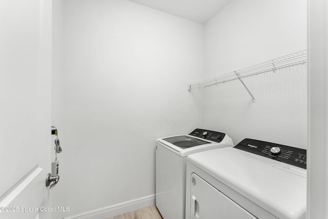 8048 Gullen Dr, Melbourne, FL 32940 - laundry room with separate washer and dryer, baseboards, laundry area, and light wood-style flooring