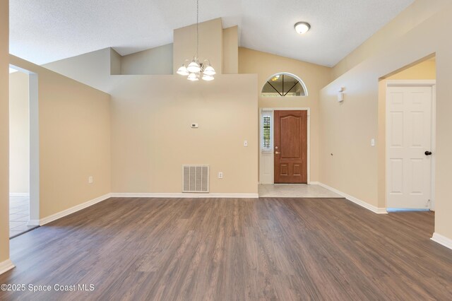entryway with an inviting chandelier, visible vents, wood finished floors, and baseboards