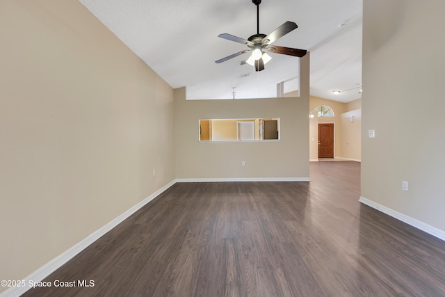 empty room with dark wood-type flooring, a ceiling fan, high vaulted ceiling, and baseboards