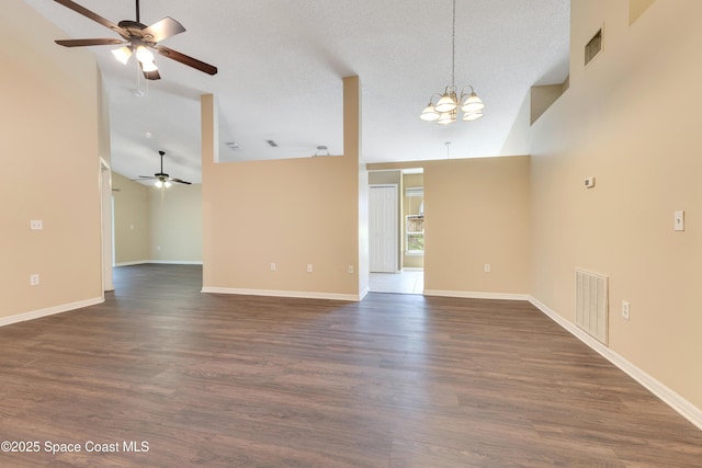 unfurnished living room with visible vents, ceiling fan with notable chandelier, and dark wood-style flooring