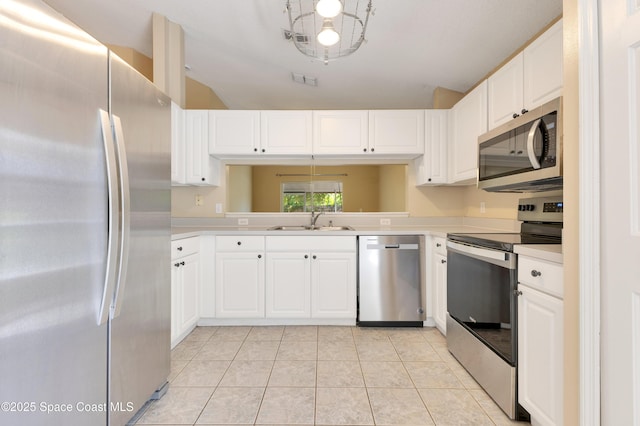 kitchen featuring a sink, light tile patterned floors, light countertops, white cabinets, and appliances with stainless steel finishes
