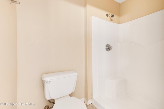 bathroom featuring toilet and a shower