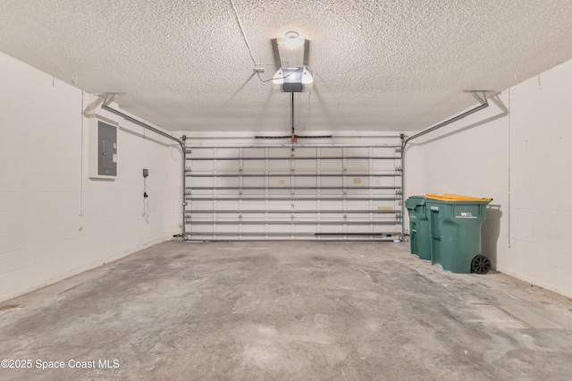 garage featuring a garage door opener, concrete block wall, and electric panel