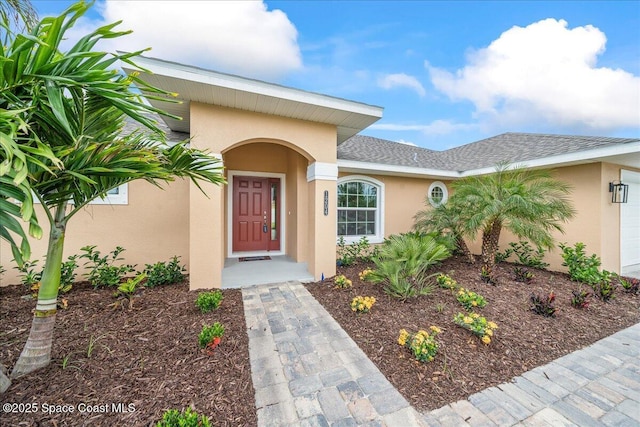 1204 Captiva Island Cir SW, Palm Bay, FL 32908 - doorway to property with stucco siding, a garage, and a shingled roof