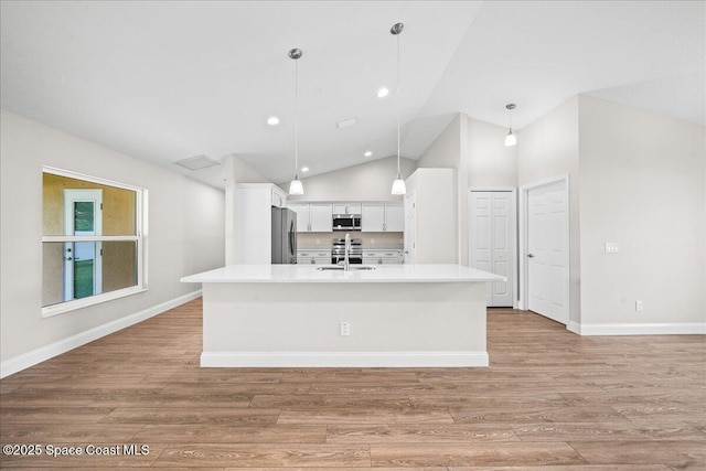 1204 Captiva Island Cir SW, Palm Bay, FL 32908 - kitchen featuring appliances with stainless steel finishes, white cabinets, light wood-type flooring, lofted ceiling, and light countertops