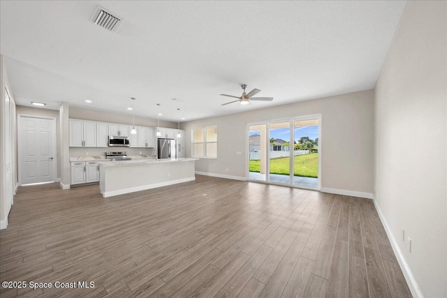 1035 Captiva Island Cir SW, Palm Bay, FL 32908 - unfurnished living room with baseboards, light wood finished floors, ceiling fan, and recessed lighting