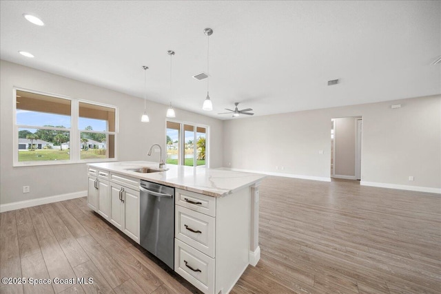 1035 Captiva Island Cir SW, Palm Bay, FL 32908 - kitchen with stainless steel dishwasher, a sink, light wood finished floors, baseboards, and white cabinets