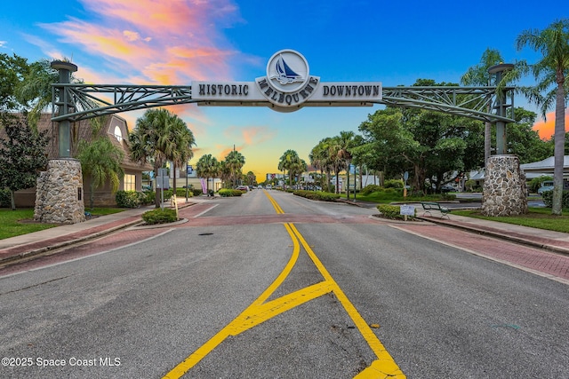 view of asphalt road featuring sidewalks, curbs, and street lights