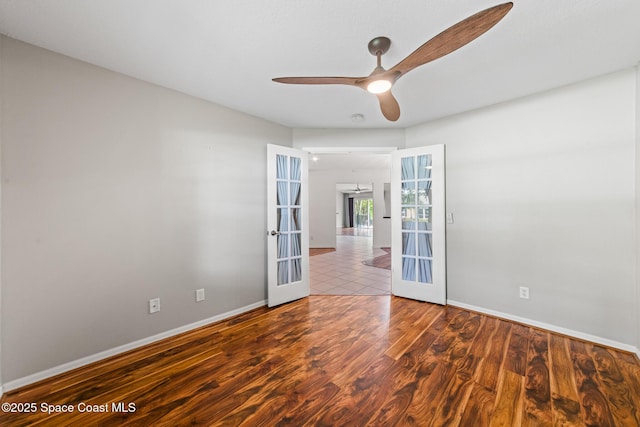 empty room featuring french doors, ceiling fan, baseboards, and wood finished floors