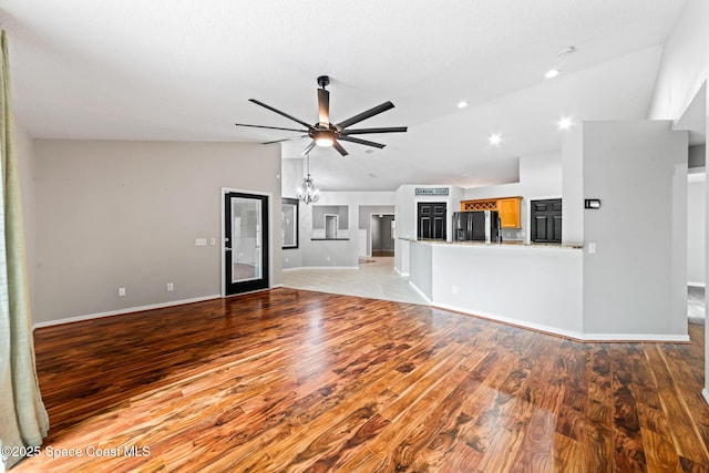 unfurnished living room featuring lofted ceiling, a ceiling fan, light wood finished floors, baseboards, and recessed lighting
