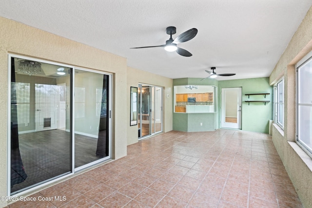 unfurnished sunroom featuring a textured ceiling and tile patterned flooring