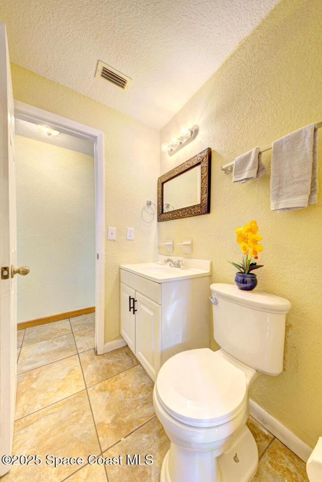 bathroom with tile patterned flooring, visible vents, toilet, and vanity